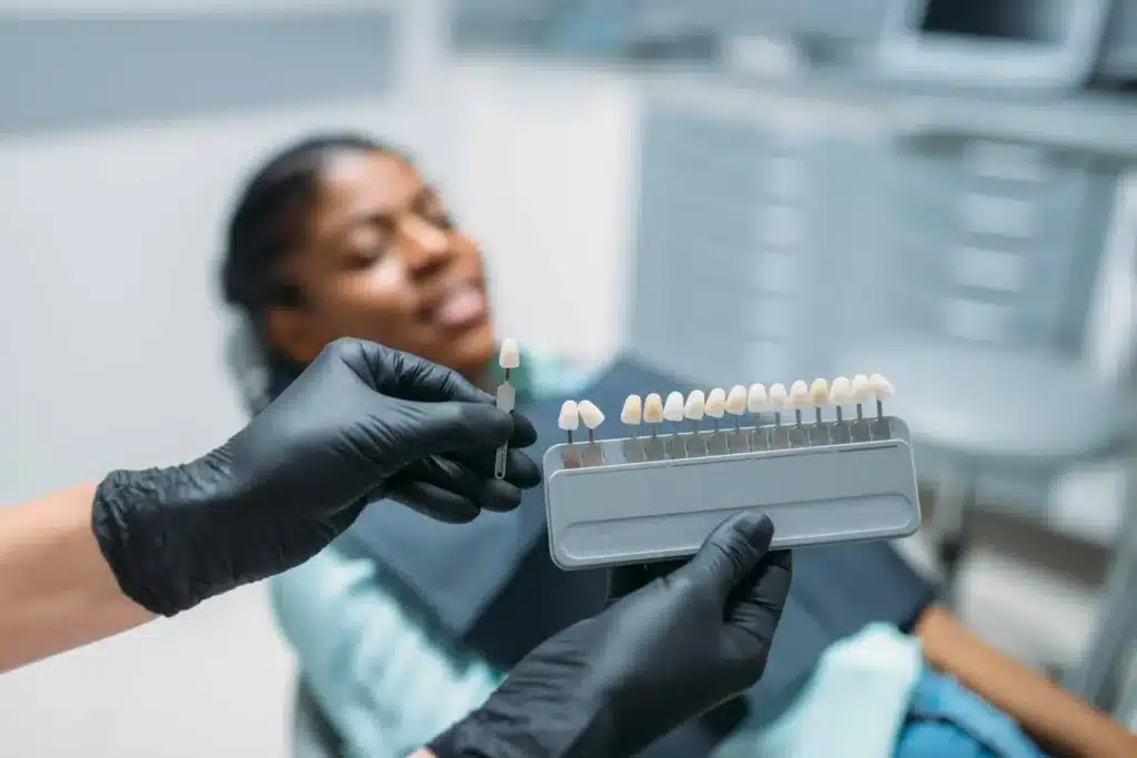 Dentist choosing the shade of teeth, dental clinic