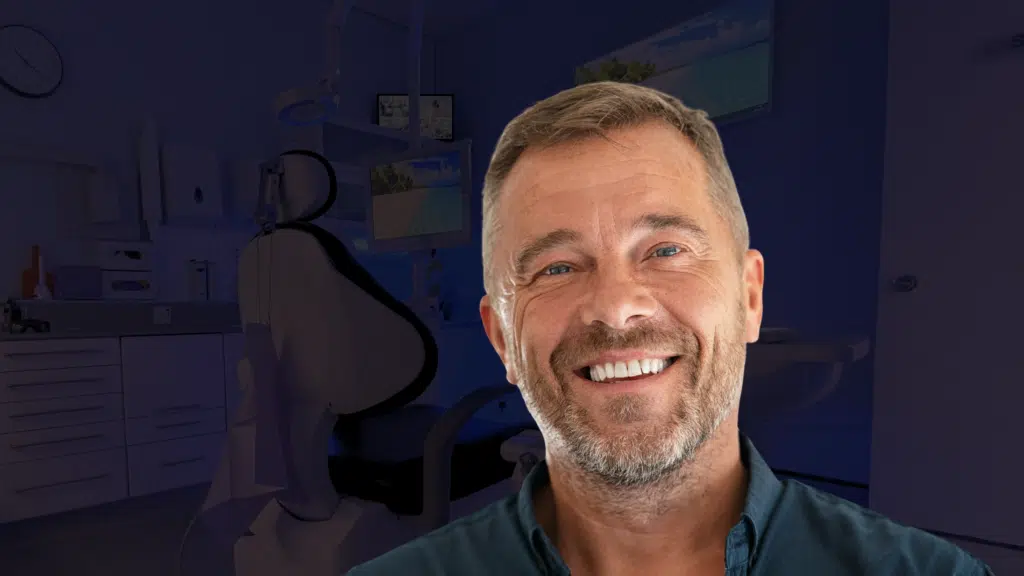 A male patient smiling after a painless tooth extraction in London