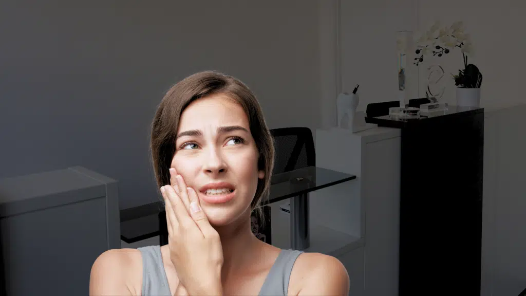Person holding their jaw in pain TMJ headache | tmj headache treatment at Smile Cliniq | tmj headache | tmj headache